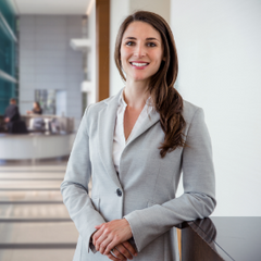 Woman in a gray suit standing in an office setting